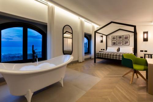 a bathroom with a tub and a bedroom with a bed at Maison Bon Bon in Sorrento