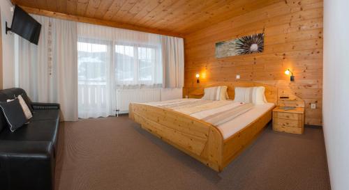 オーバーアウにあるPension Anderlaの木製の部屋にベッド1台が備わるベッドルーム1室があります。