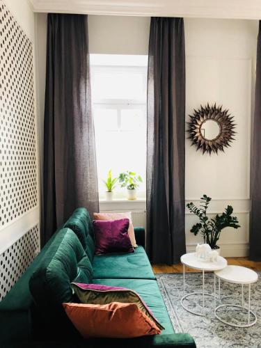 a green couch in a living room with a window at Piper Park Wilsona & Targi in Poznań