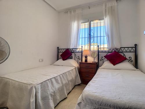 1 Schlafzimmer mit 2 Betten und einem Fenster in der Unterkunft Ribera Beach 2 - 1509 in Mar de Cristal