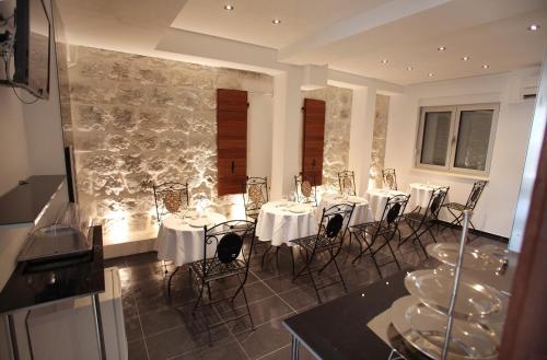 Villa Kampanel في تروغير: غرفة طعام مع طاولات وكراسي بيضاء