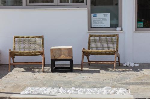 two chairs sitting in front of a building at Golden Beach Hotel in Chrissi Akti