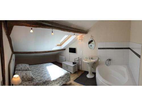 a bathroom with a bed and a tub and a sink at La Ferme des Moulineaux in Bailly