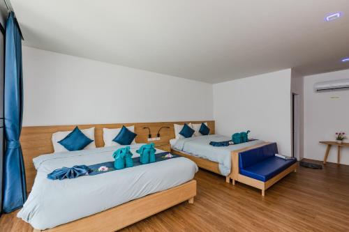 1 dormitorio con 2 camas y silla azul en Paradise Resort Phi Phi-SHA Plus, en Islas Phi Phi