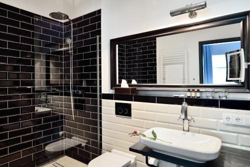 a black and white bathroom with a sink and a mirror at Syte in Mannheim