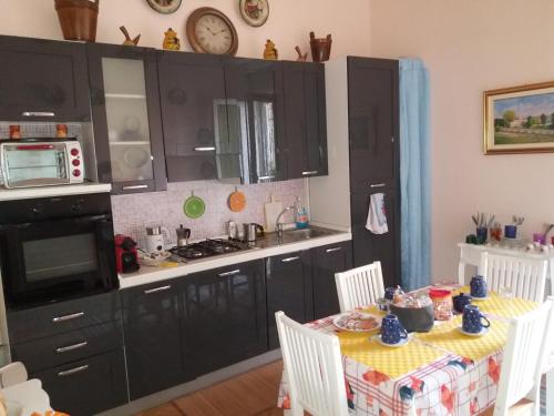 a kitchen with black cabinets and a table with chairs at Da Selly in Mantova