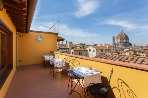 a patio area with chairs, tables, and umbrellas at Palazzo Graziani in Florence