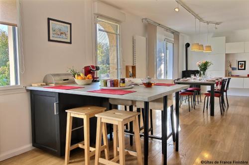 une cuisine et une salle à manger avec une table et des chaises dans l'établissement MA MAISON A LA MER, à Fouesnant