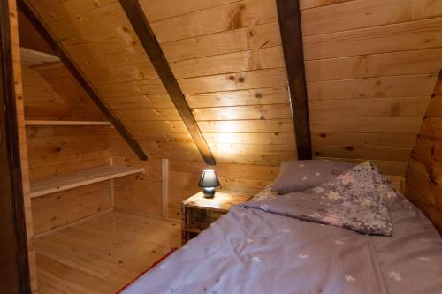 a bedroom with a bed in a wooden cabin at Brvnara na bregu in Bajina Bašta