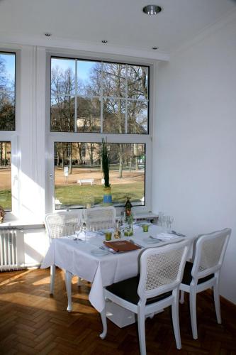 a white table with white chairs and a window at Alte Villa Schlossblick in Bad Pyrmont