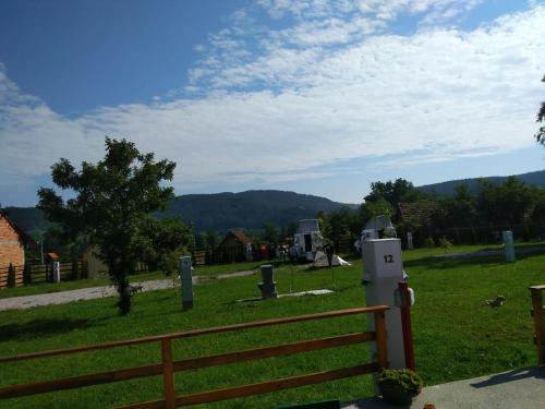 a field with a fence and a mountain in the background at Apartments&Camping ZIP in Kremna