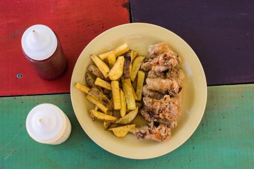 a plate of food with french fries on a table at The Upcycled Hostel Huacachina in Ica