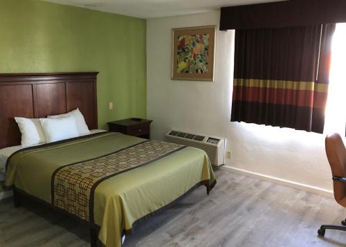 a hotel room with a bed and a window at Americas Best Value Inn Visalia in Visalia