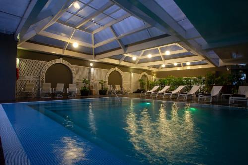 a large swimming pool with chairs and a ceiling at Casa Andina Premium Miraflores in Lima