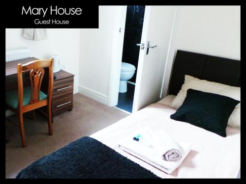 a bedroom with a bed and a chair and a desk at Mary House 46 in Porthcawl