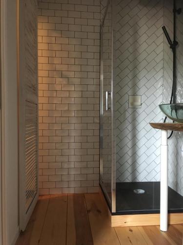 La salle de bains est pourvue d'une douche et d'une paroi en verre. dans l'établissement B&B Les Hauts d'Ornans, à Ornans