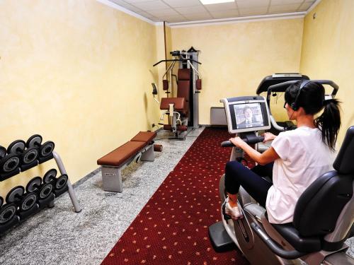 a woman sitting in a chair in a gym looking at a computer at Stella Alpina Hotel e Ristorante in Druogno