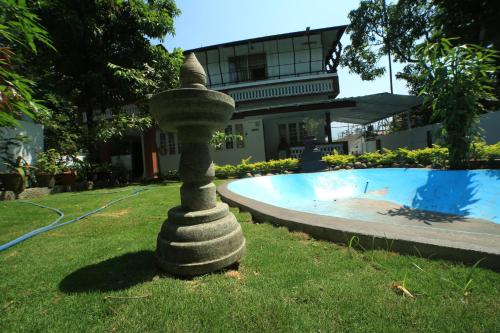 a stone tower sitting in the grass next to a pool at Gokulam Home Stay in Munnar