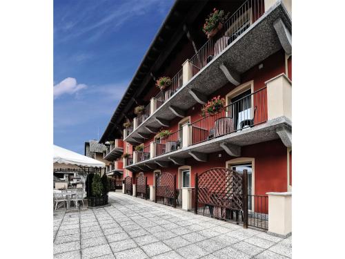 a building with red walls and balconies on a street at Stella Alpina Hotel e Ristorante in Druogno