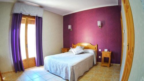 1 dormitorio con cama y pared púrpura en Hs San Francisco - CÉNTRICO en Almagro