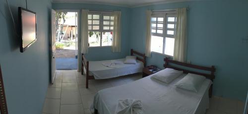 1 dormitorio con 2 camas y 2 ventanas en Big Valley Hotel Fazenda, en Serra Negra