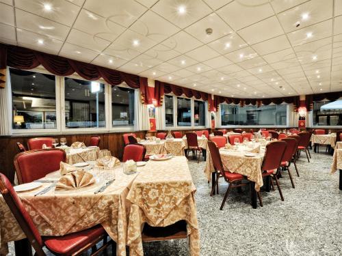 a dining room with tables and red chairs and tablesearcher at Stella Alpina Hotel e Ristorante in Druogno