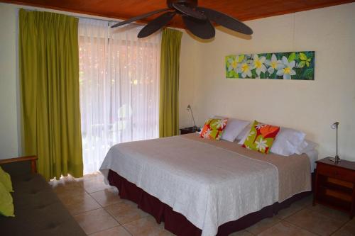 Marae - Cabañas Premium في هانجا روا: غرفة نوم بسرير ومروحة سقف