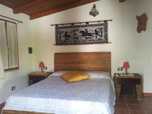 een slaapkamer met een bed en twee nachtkastjes met lampen bij Sa Figu Morisca in Solanas