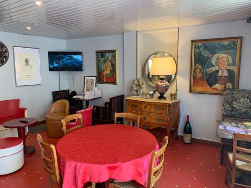 Longeau的住宿－伊迪絲酒店，一间设有红色桌子和镜子的客房