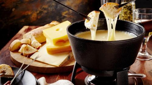 a pot of soup with bread and cheese on a table at Cabaña Pica Piedra in Mendoza