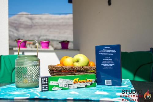 a table with a box of fruit and a book at Studio apartmani Milović in Trebinje