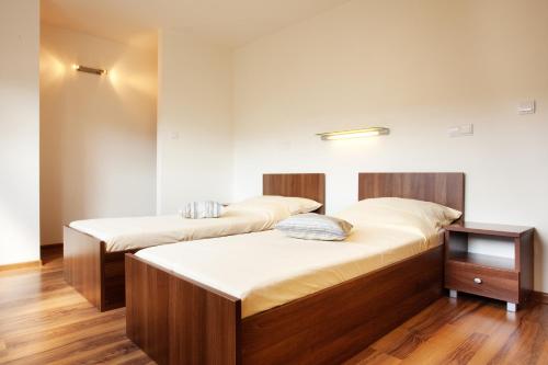 two beds in a room with wooden floors at Vila Element in Jeseník