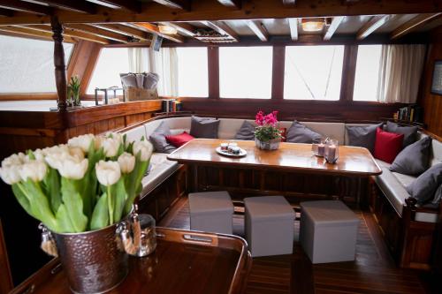 Habitación en barco con sofá y mesa con flores en Caicco Lycian Princess, en Venecia