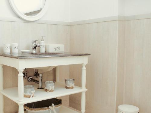 a bathroom with a white table and a sink at The Bell Tower Lodge in Palidoro