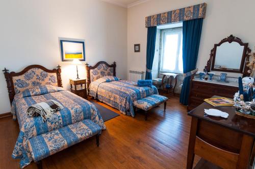 a bedroom with a bed and a couch and a table at Hospedaria do Convento d'Aguiar- Turismo de Habitacao in Figueira de Castelo Rodrigo