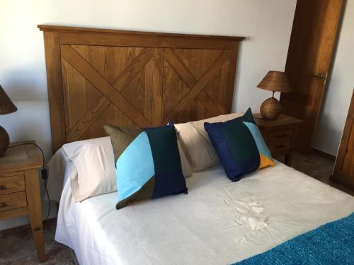 a bed with a wooden headboard and pillows on it at Apartamento situado en el centro de Santa Cruz in Santa Cruz de Tenerife