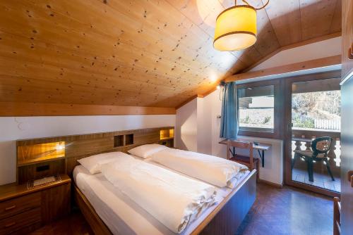 a bedroom with a large bed with a wooden ceiling at Gasthof Specker in Obereggen