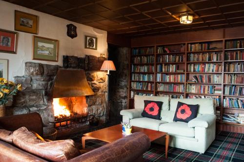 - un salon avec un canapé et une cheminée dans l'établissement Loch Ness Lodge Hotel, à Drumnadrochit