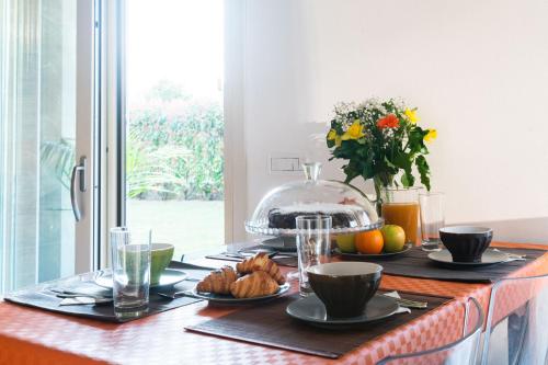 un tavolo con piatti di cibo e una ciotola di frutta di Oasi a Bergamo