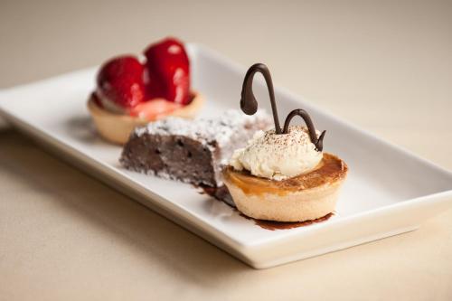 a white plate with two desserts on a table at Loch Ness Lodge Hotel in Drumnadrochit