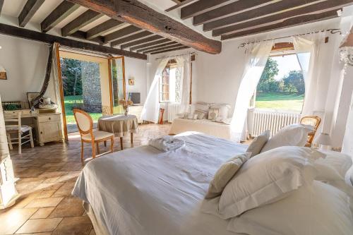 een slaapkamer met een groot bed en een bureau bij Le Colombier de Hanches - Teritoria in Hanches