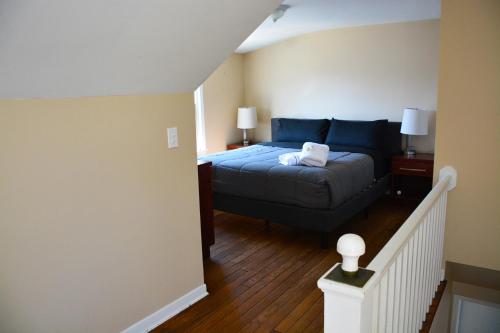 a small bedroom with a bed and a staircase at Stunning Downtown Royal Oak Townhouse (909) in Royal Oak