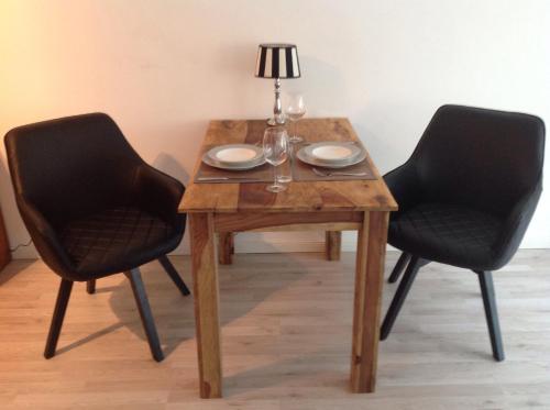 ティメンドルファー・シュトラントにある1-Zimmer-Appartment Miamiの木製テーブル(椅子2脚、ランプ付)