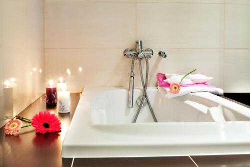 a white bath tub with pink flowers on a table at Vila Element in Jeseník