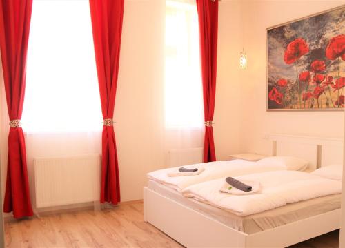 sypialnia z łóżkiem z czerwonymi zasłonami w obiekcie Flowers apartments w Pradze