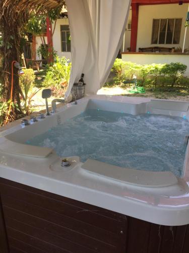 a bath tub filled with water in a yard at Puerto Galera Hostel in Puerto Galera