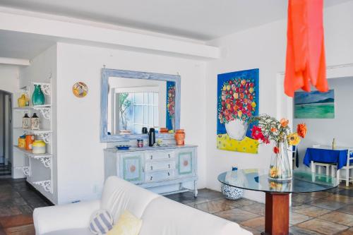 a living room with a table and a mirror at Pousada Kopenhagen Beach in Cabo Frio