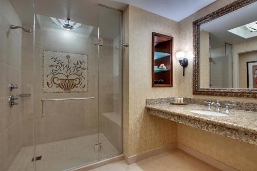 uma casa de banho com um chuveiro e um lavatório. em Argosy Casino Hotel & Spa em Kansas City