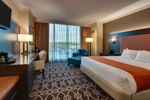 a hotel room with a large bed and a chair at Argosy Casino & Hotel in Kansas City