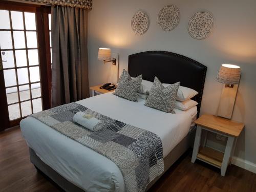 a bedroom with a large bed with pillows on it at Shonalanga Lodge in Vryheid